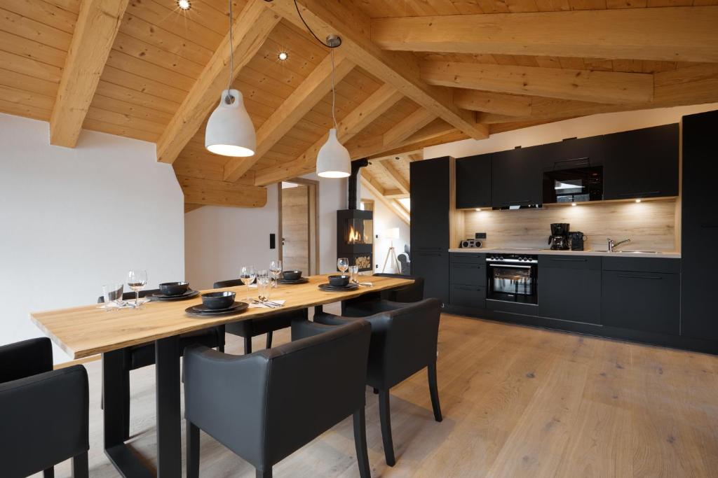 格赖瑙Zugspitzerei - Premium Chalet Ferienwohnungen的用餐室配有木桌和黑椅子