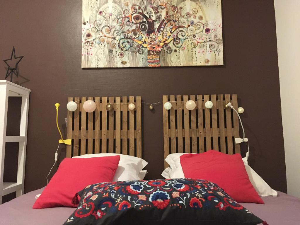 Nanteuil-sur-MarneL auberge du lion d or的一间卧室配有一张带红色枕头的床和一幅画
