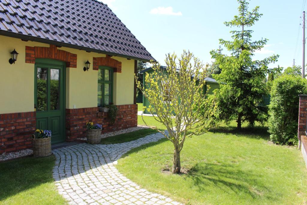 格雷芬海尼兴Ferienwohnung Zum Alten Gaswerk的院子中一棵树的小房子