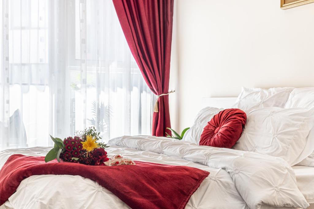 阿拉德ARI RED Apartment în complexul Ared Kaufland的一张白色的床,上面有红毯和鲜花
