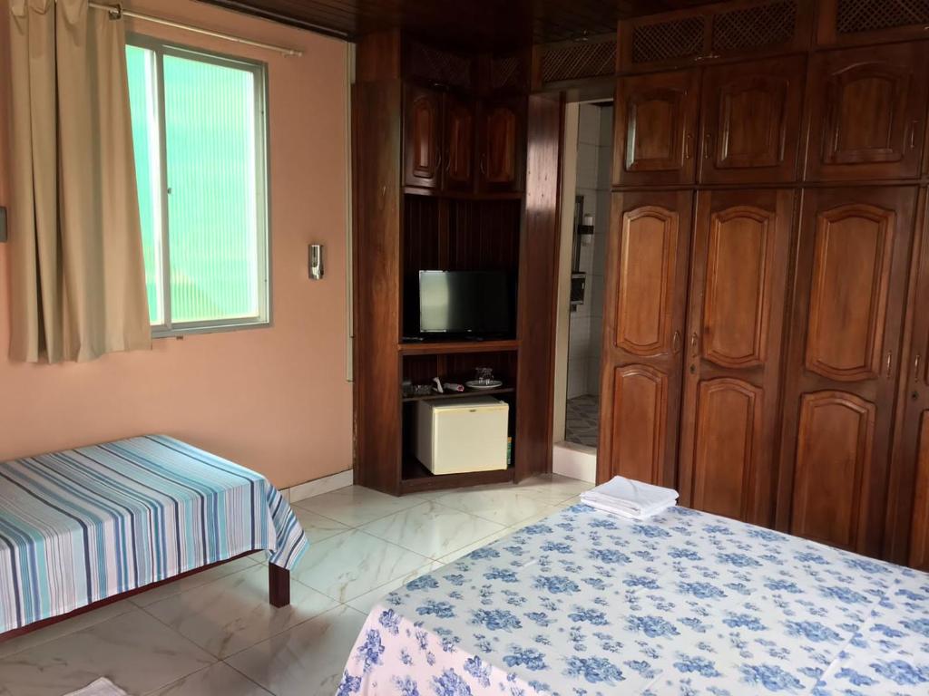 索雷Apartamento Suíte em Soure.的一间卧室设有一张床、一台电视和一个窗口。