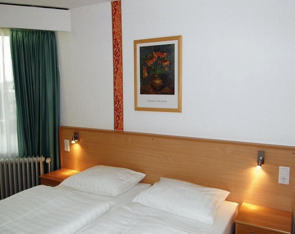 巴特嫩多夫Hotel Deisterblick的卧室配有一张床,墙上挂着一幅画