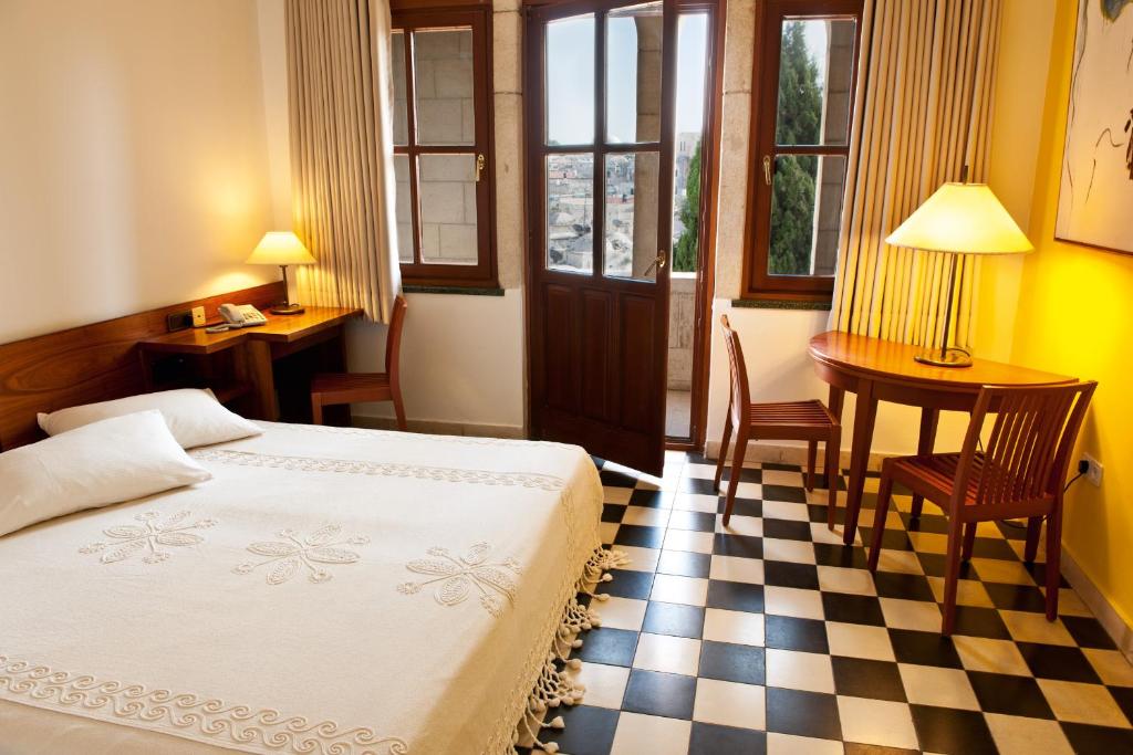 耶路撒冷Austrian Pilgrim Hospice的一间卧室设有一张床和一个 ⁇ 板地板