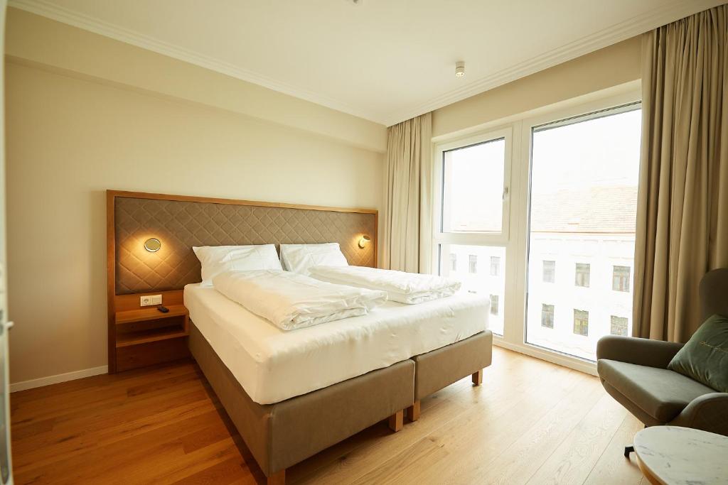 维也纳Green Leisure Apartments Schweglerstrasse的一间卧室设有一张床和一个大窗户