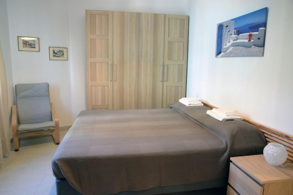圣玛格丽塔-利古雷Sunrise Apartment的一间卧室配有一张大床和一把椅子