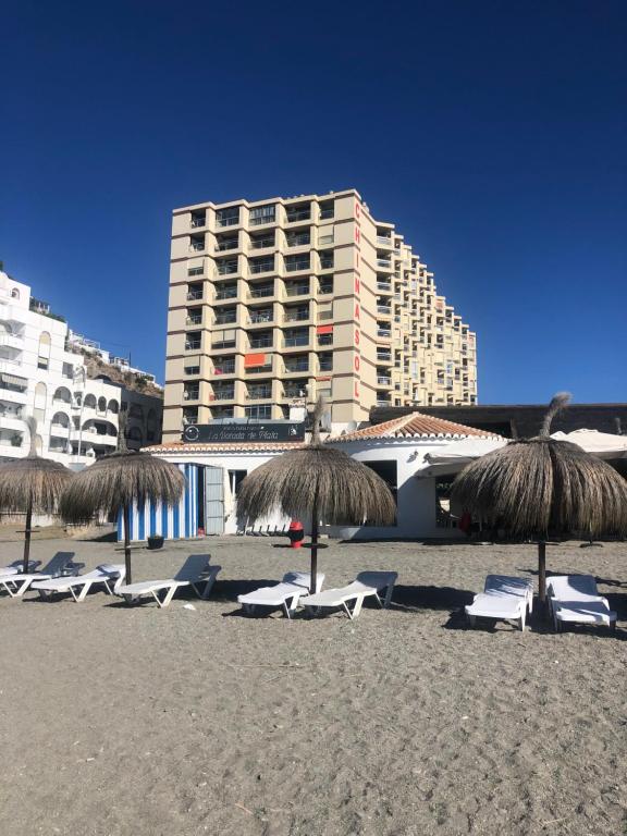 阿尔姆尼卡Estudio Luxury Primera Linea de Playa Almuñecar Parking Gratuito的海滩上的一组椅子和遮阳伞