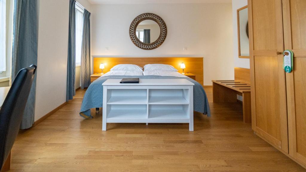 布勒Hôtel du Cheval Blanc - City center的卧室配有一张床,墙上设有镜子