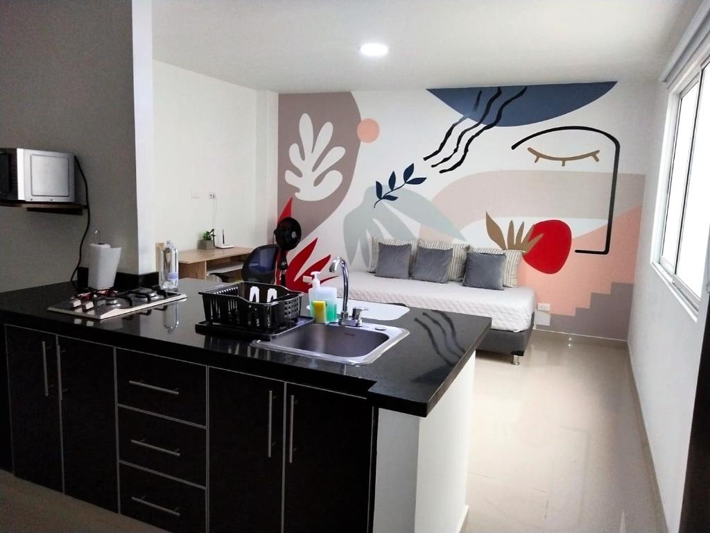 卡利Apartaestudio Arboleda del Ingenio的一个带水槽的厨房和一张位于客房内的床