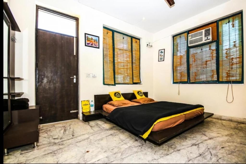 新德里Heistel Delhi的一间卧室配有一张带黄色枕头的大床