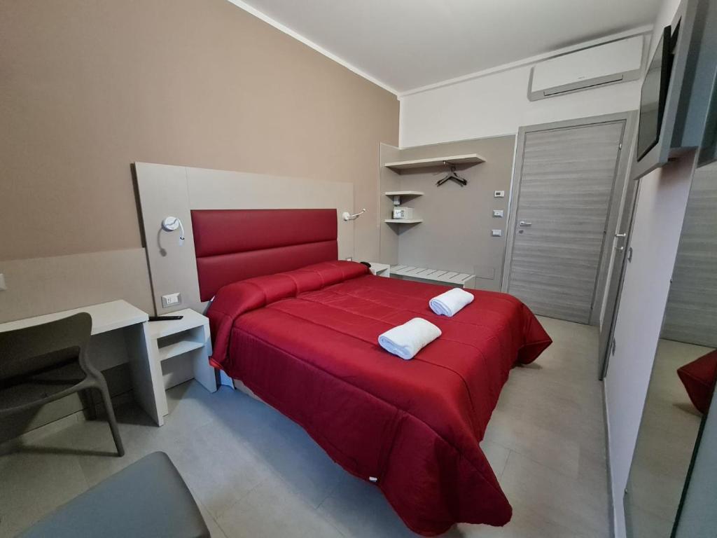 米兰hotel city 20的一间卧室配有红色的床和两个枕头