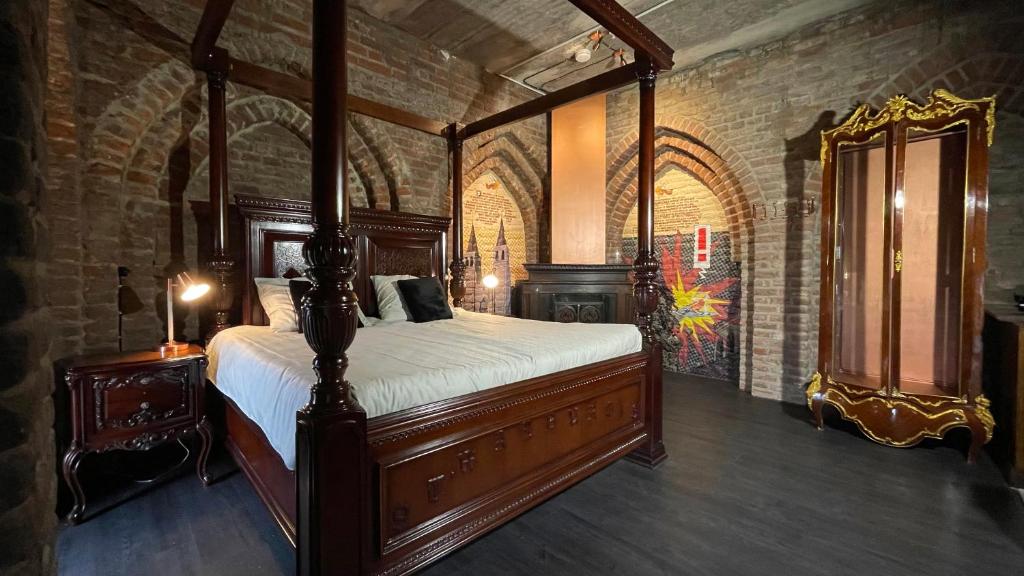 阿纳姆Walburgis Residenties的卧室配有一张位于砖墙的天蓬床