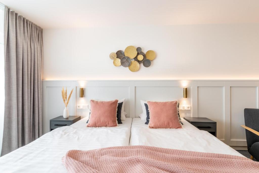 明登拜德明登酒店的卧室配有带粉红色枕头的大型白色床