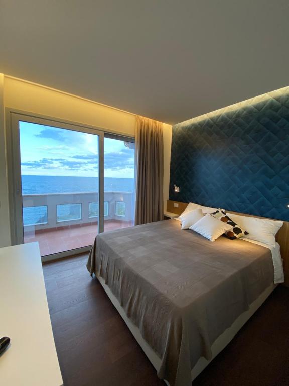 卡塔尼亚Suite Sul Mare的一间卧室设有一张大床和大窗户