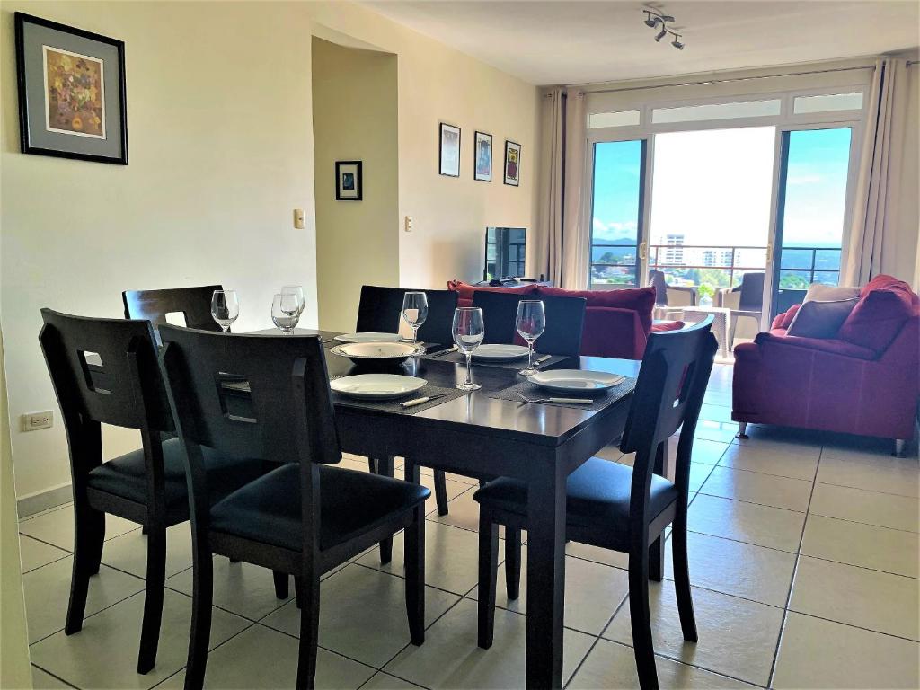 圣萨尔瓦多Luxury Modrn Apartment, w/amazing view, 3BR,Escalon,Exclus,Secur的用餐室配有桌椅和酒杯