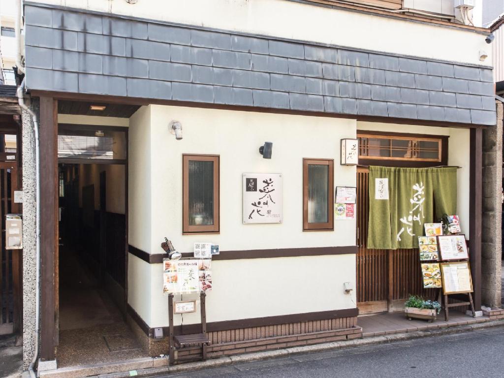京都Woman Only Guesthouse Nanohana (Female only)的一座白色的小建筑,有黑色的屋顶
