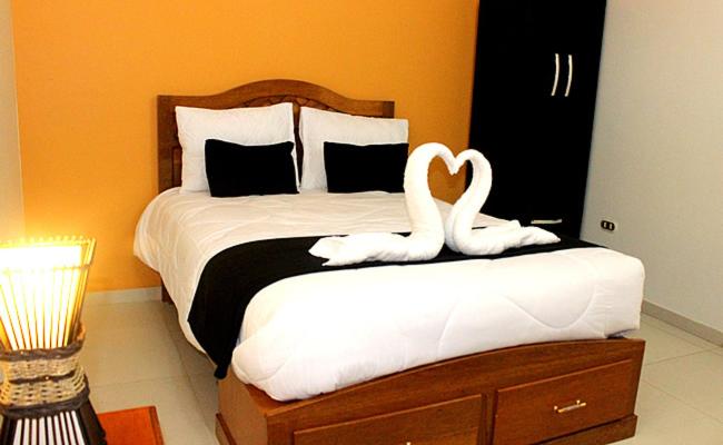 瓦拉斯胡瓦拉茨全球旅馆的一间卧室配有一张带两个天鹅的床