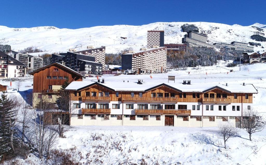 里蒙纽耶Odalys Chalet D'Alice的一座大木屋,位于一个城市的雪中