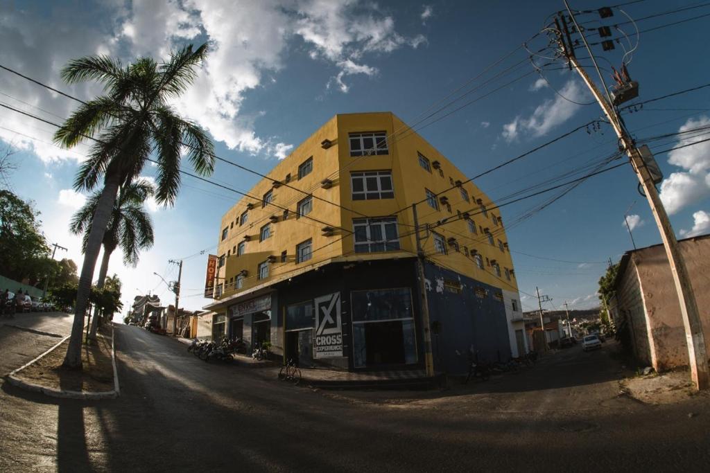萨利纳斯Eldorado Palace Hotel的一条棕榈树街道上的黄色建筑