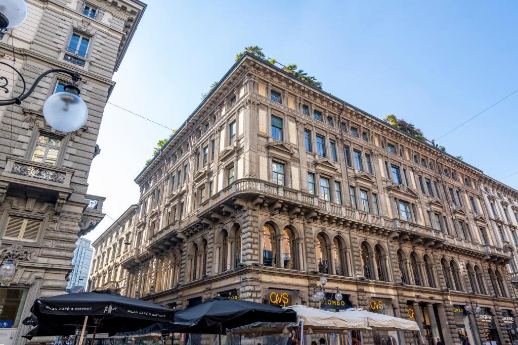 米兰Imperiale Suites Milano的前面有雨伞的大建筑