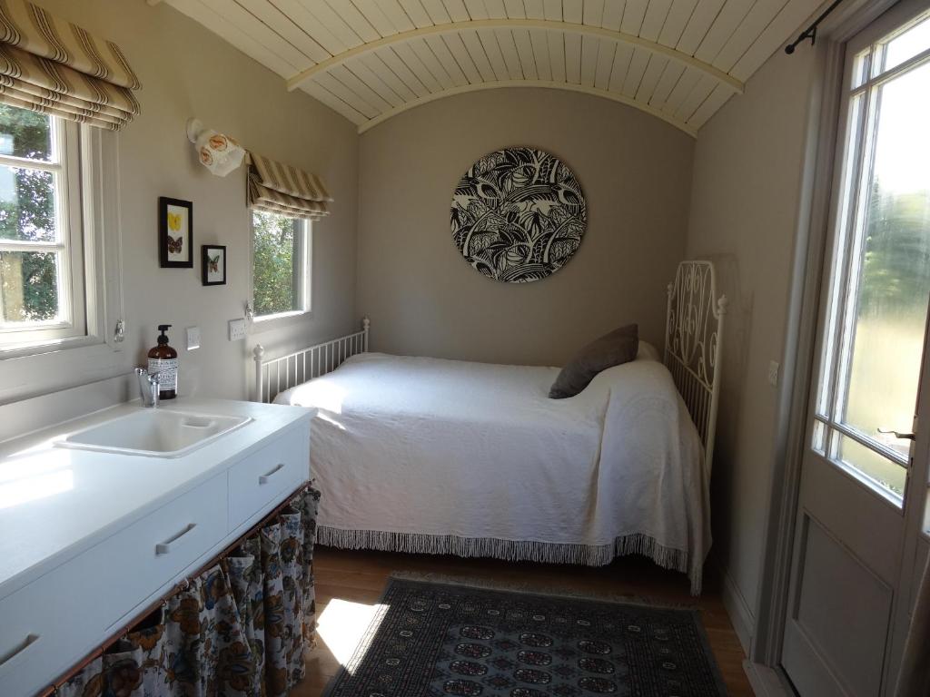 ColkirkThe Oaks Glamping - Rubie's Shepherds Hut的一间卧室配有床、水槽和窗户