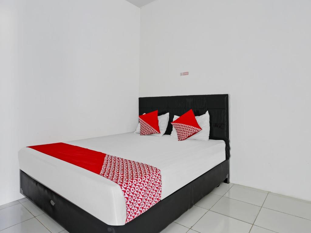 沙马林达SUPER OYO 90550 Good Sleep 3 Samarinda的一张带红色和白色枕头的床