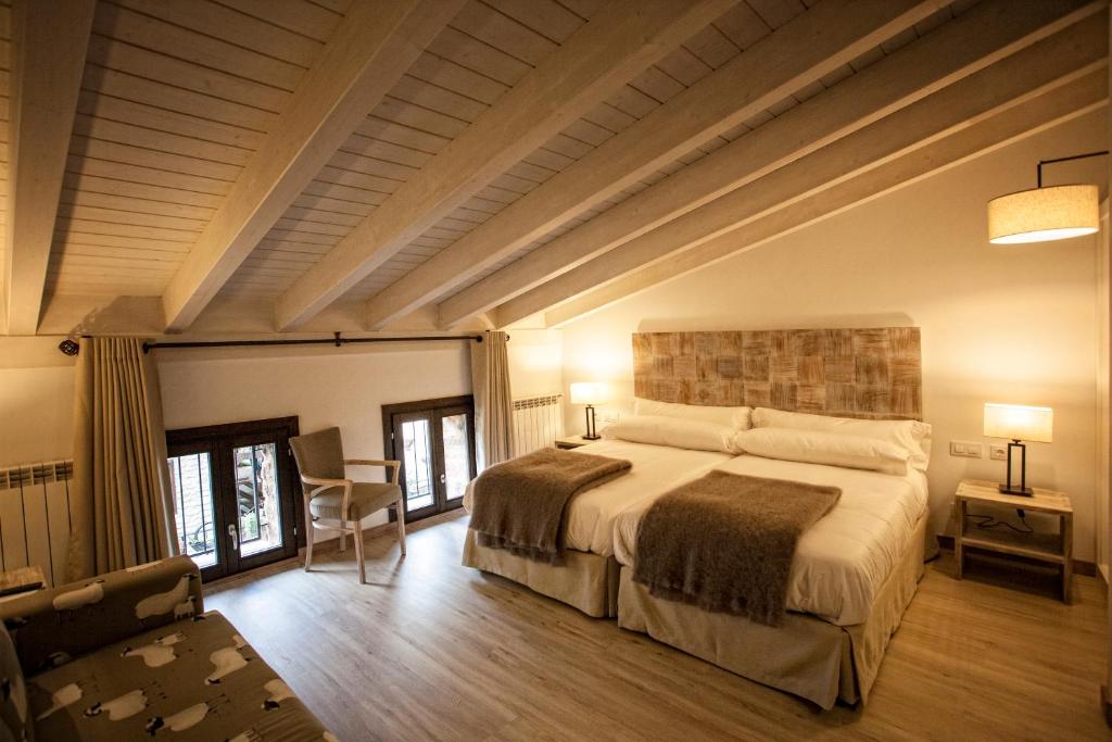 Valgañón普拉维达酒店 的一间卧室,卧室内配有一张大床