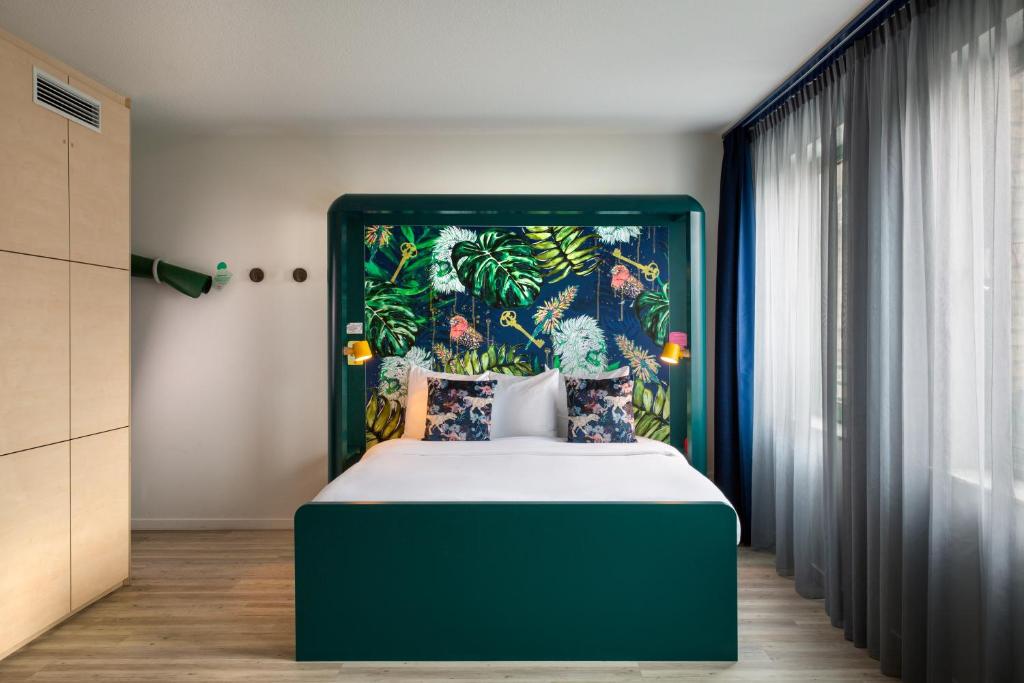 布鲁塞尔B&B HOTEL Brussels Centre Louise的一间卧室配有一张大床和绿色床头板
