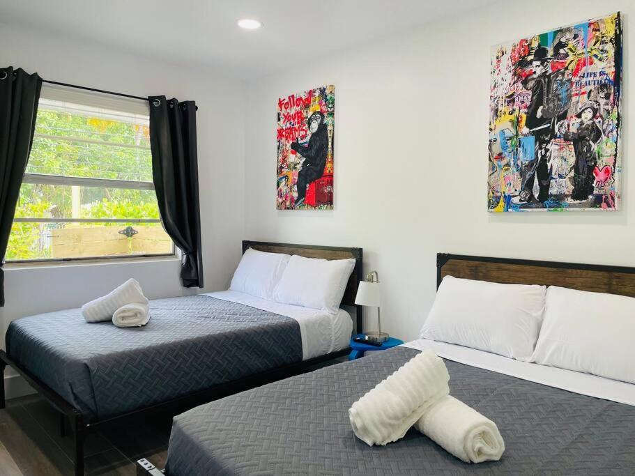 迈阿密Casa Wynwood 4BR 2BTH的一间卧室设有两张床和窗户。