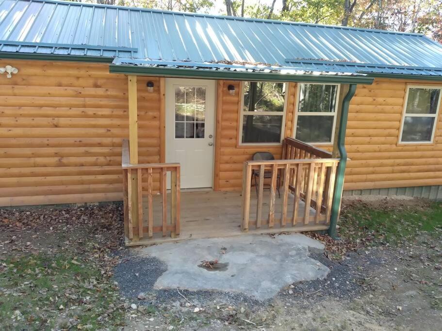 MarshallCabin with a tree house on a buffalo farm .的小屋设有门廊和白色门