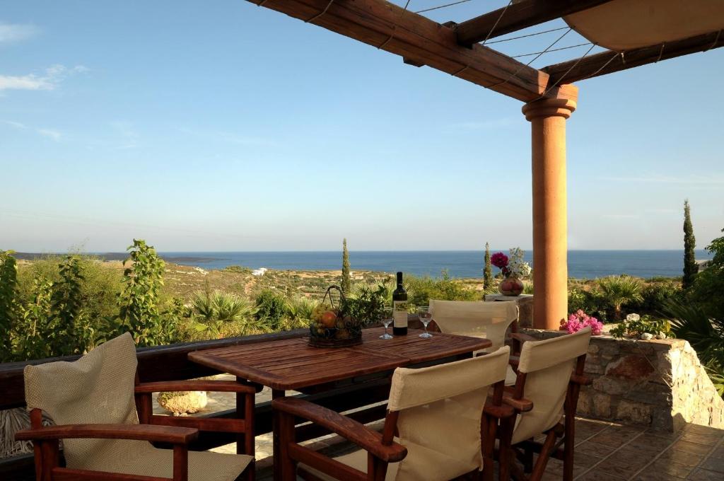埃弗勒莫纳斯Palaeopoli Villas的露台的桌椅,背景为大海