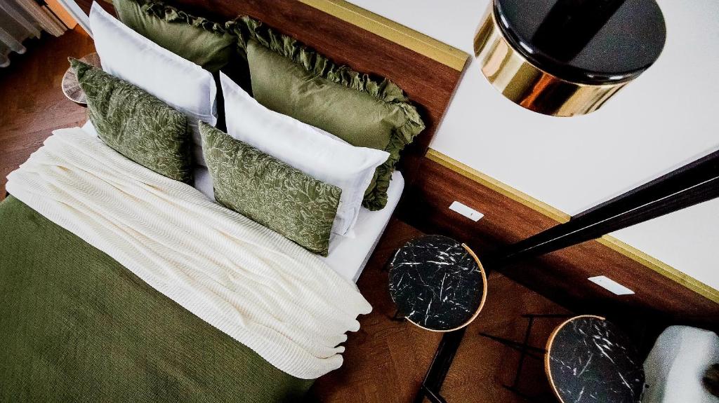 维尔纽斯Old Town apartment l Self check in的一张带绿色和白色枕头的床和一盏灯