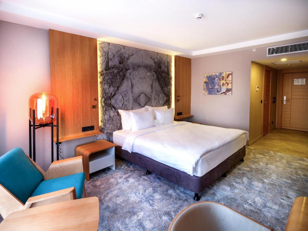 埃斯基谢希尔Grande Arte Hotel的酒店客房带一张大床和椅子