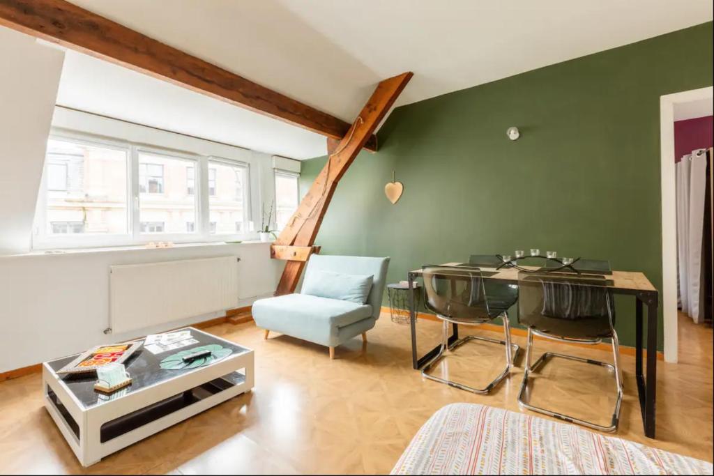 瓦朗西纳Apt Cocooning, 54m2, Centre的客厅设有桌子和绿色的墙壁