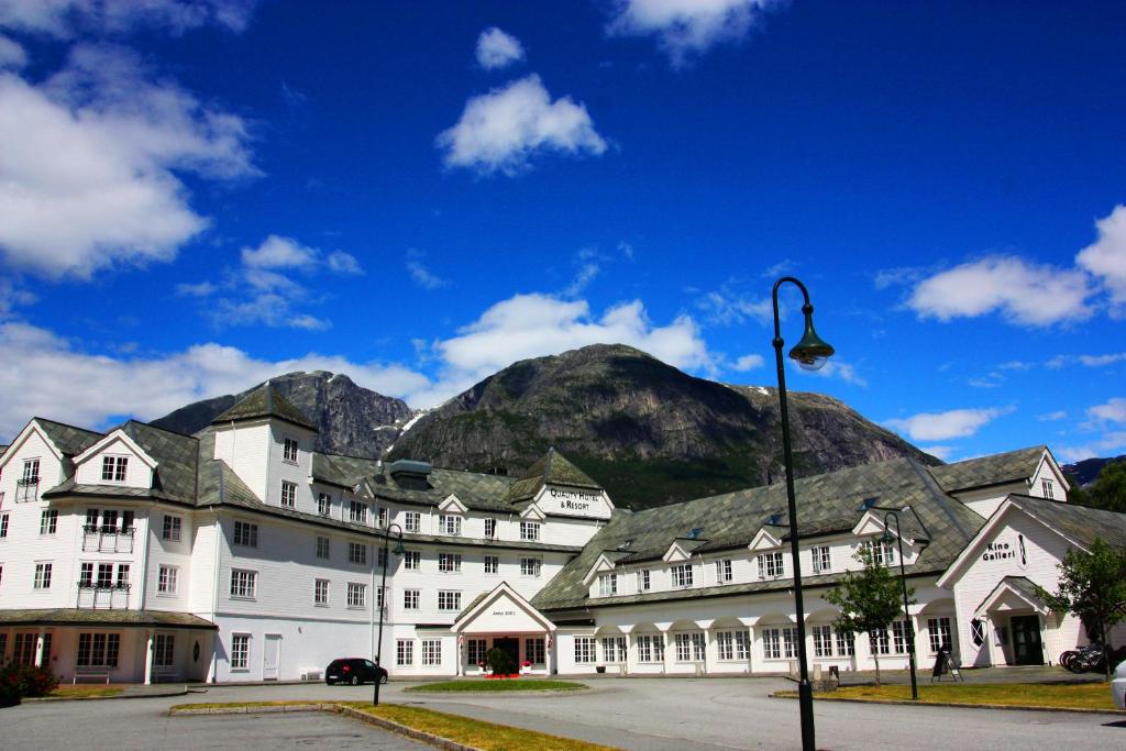 艾菲约德Vøringfoss Hotel的一座白色的大建筑,背景是一座山