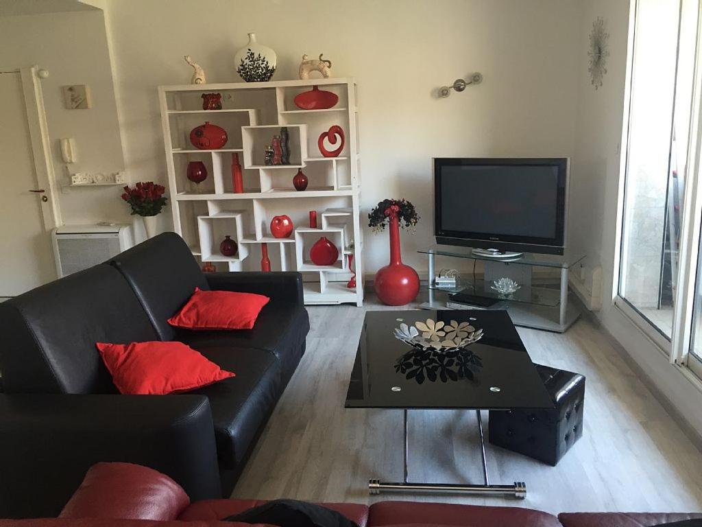 马赛MAGNIFIQUE T3 85m2 VIEUX PORT/CORNICHE的客厅配有黑色沙发和电视