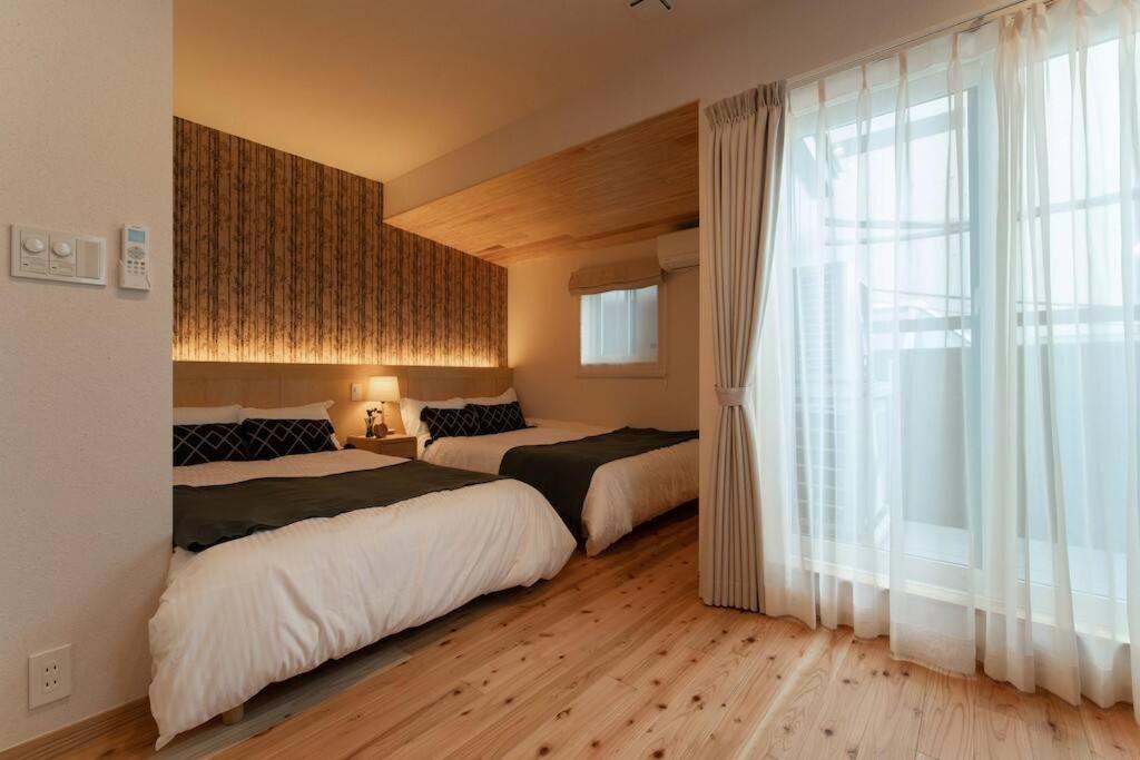 EbisuchōOCHANOMA的一间卧室设有两张床和大窗户