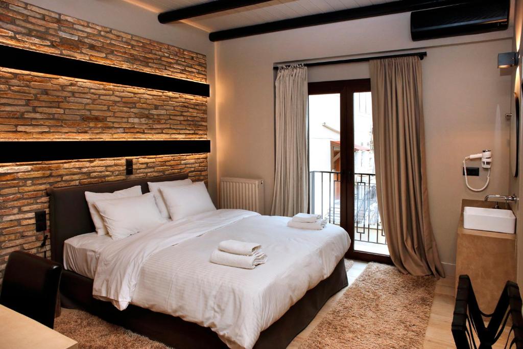 卡拉维塔阿尼西斯酒店的一间卧室设有一张大床和砖墙