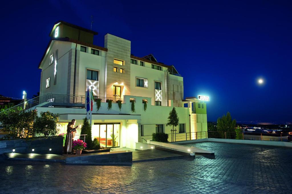 圣乔瓦尼·罗通多维托瑞亚酒店的一座建筑物,晚上有人站在建筑物前面