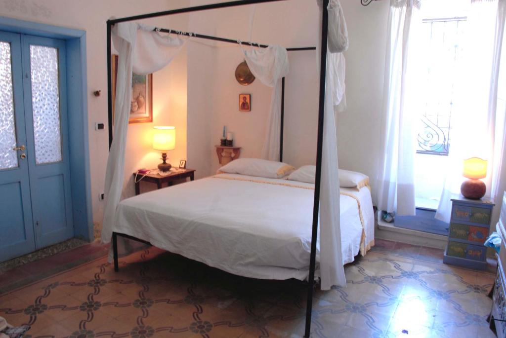 赛拉诺Casa al Sole Ponente的卧室配有带白色床单的天蓬床