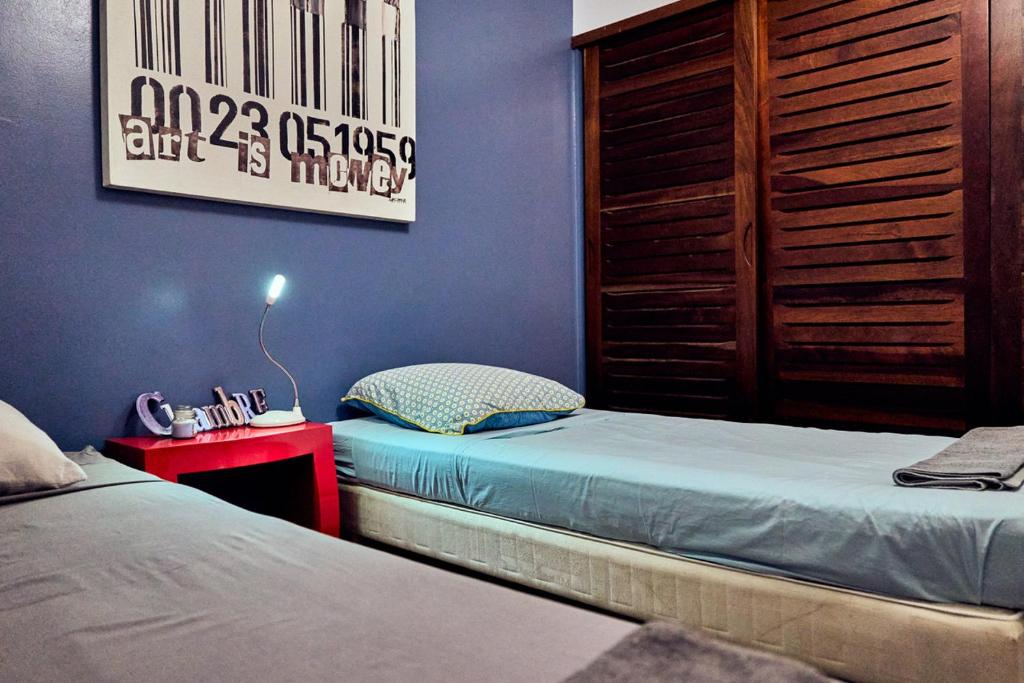 圣安尼Eden blue mer et piscine的一间卧室设有两张单人床和一张红色的桌子。