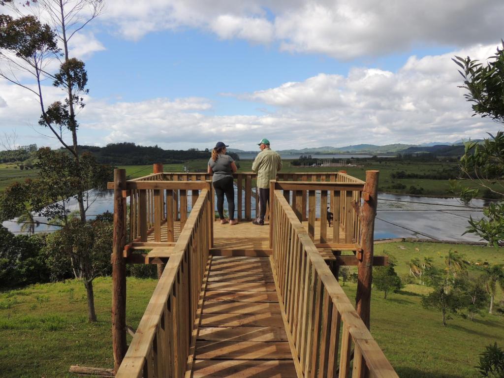 托雷斯Sítio Vô Inácio - casa inteira的两个人站在河上的木桥上
