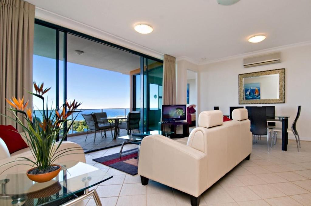 穆德吉巴圣托里尼岛双水酒店的客厅配有白色家具,享有海景。