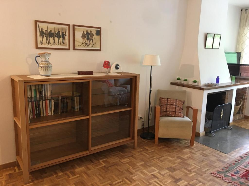 埃斯波特Apartament familiar - Els Encantats - Espot的客厅设有书架和椅子