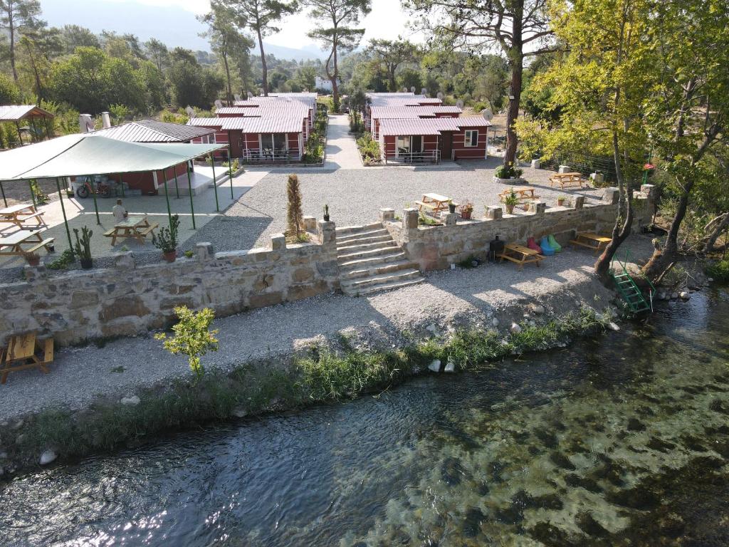 马纳夫加特Kanyon Yaşam Evleri的河边有桌椅的河流