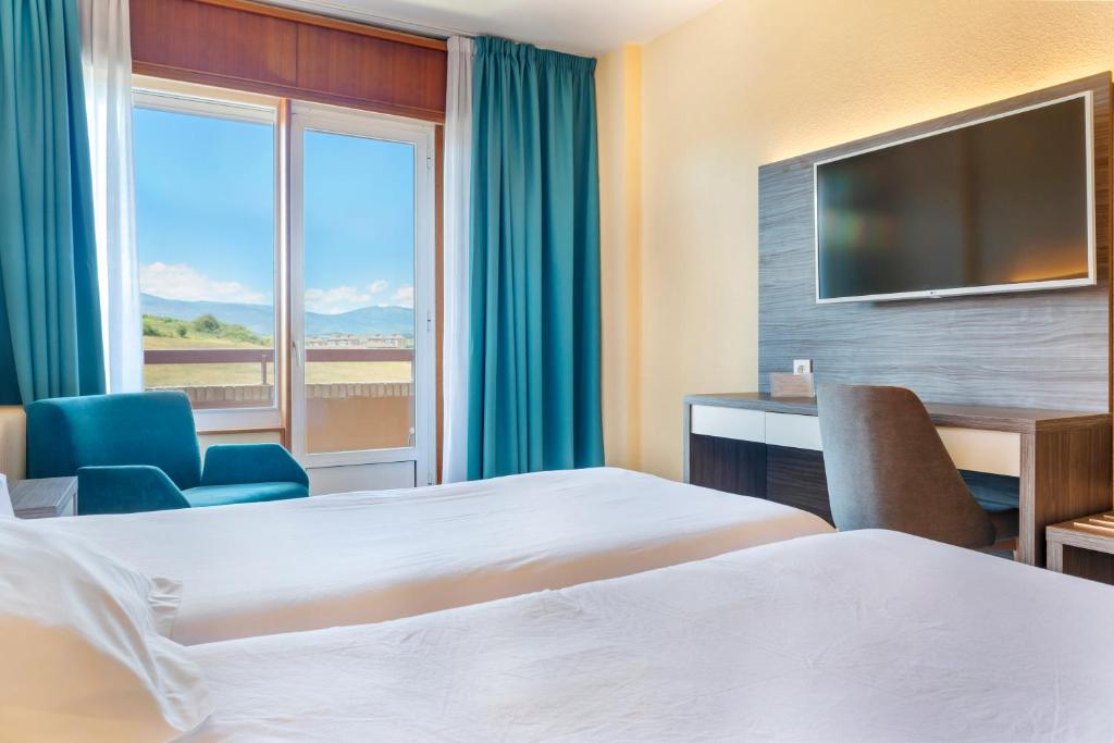 雷诺萨维约酒店的酒店客房设有两张床和大窗户。