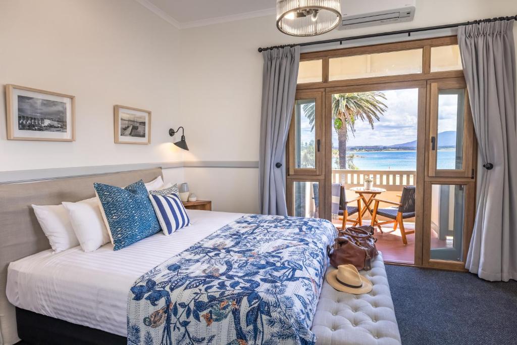 伯马吉Bermagui Beach Hotel的一间卧室设有一张床,享有海景