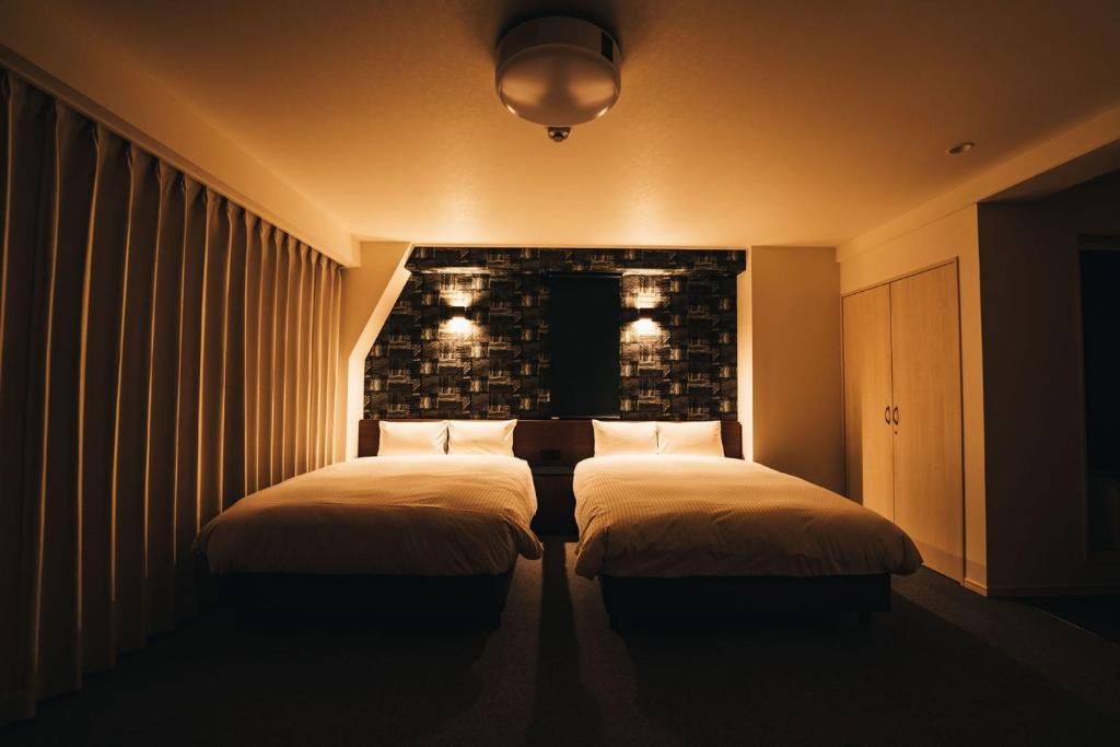 佐贺市TAPSTAY HOTEL - Vacation STAY 35227v的墙上灯的房间里设有两张床