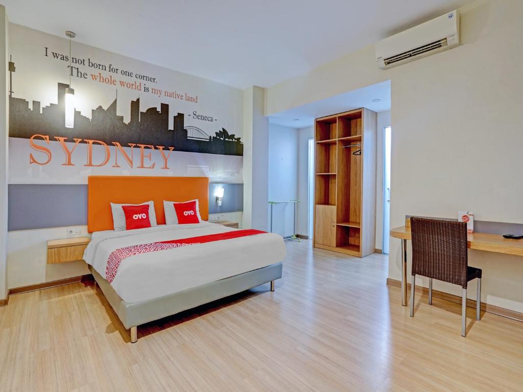 泗水Super OYO Capital O 3905 Graha 100 Guest House Syariah的一间卧室配有一张床和一张书桌