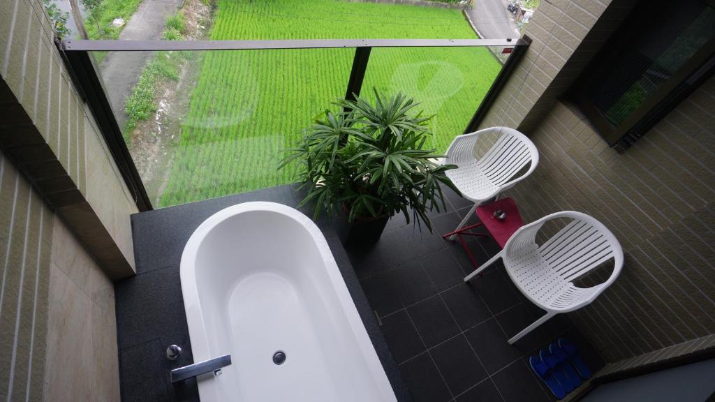 罗东镇川岸空中Villa的阳台设有带卫生间和2把椅子的浴室