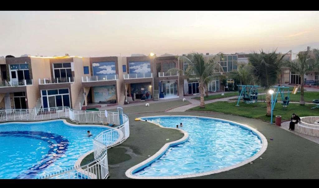 欧普尔شاليه جزيره السعاده的大型公寓大楼设有2个游泳池